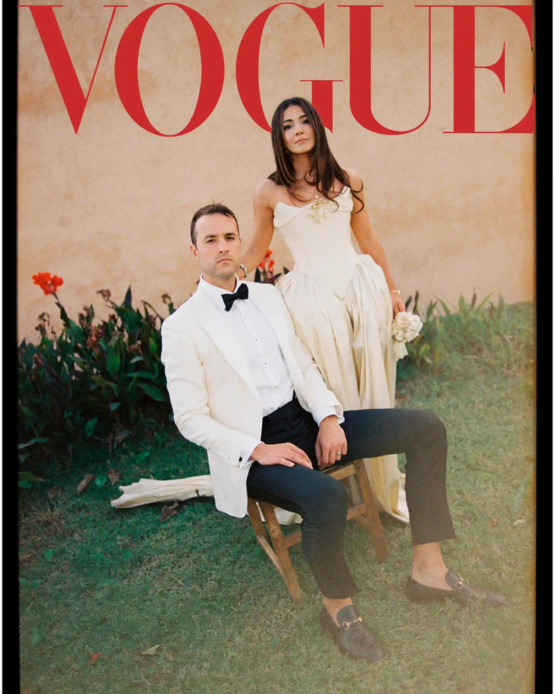 Man and woman in formal attire on a Vogue magazine cover with a beige background.